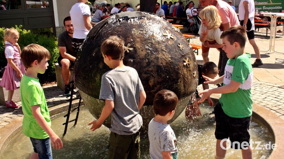 Kinder waten im Gemeindebrunnen, ein Eis geht immer bei dieser Hitze. Bild: zer