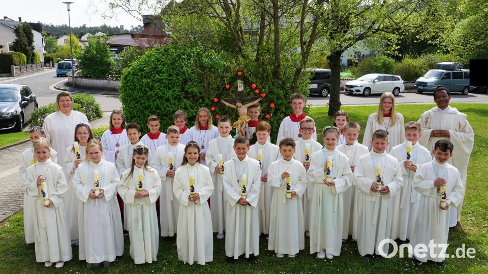 18 Kinder der Pfarreiengemeinschaft Theuern-Ebermannsdorf-Pittersberg empfangen die Erstkommunion, hier zusammen mit Gemeindereferentin Kathrin Blödt (hinten links), den Ministranten und Pater John Massawe (hinten rechts). Bild: wec
