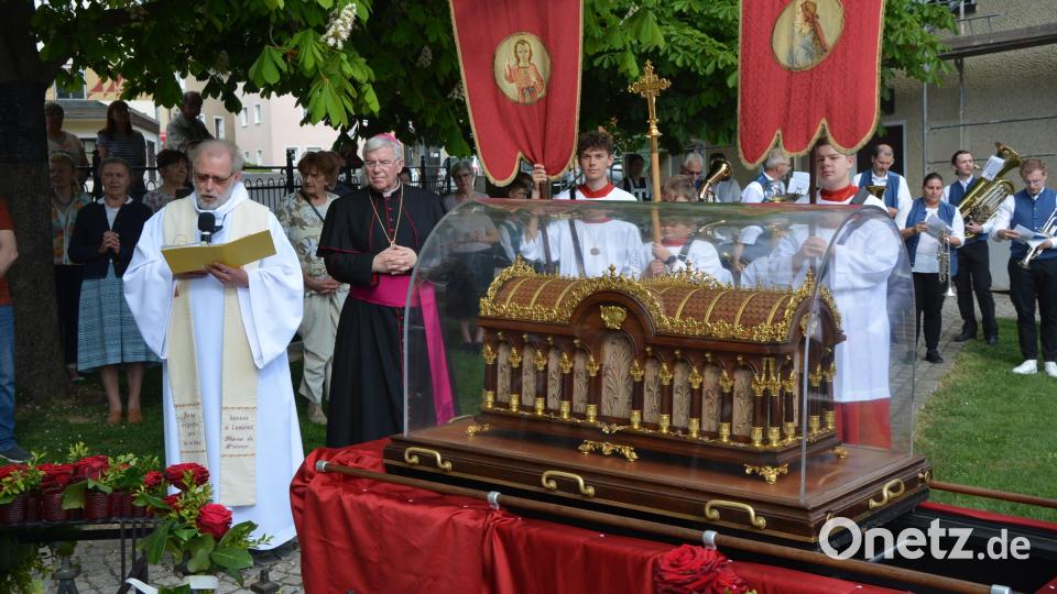 Am geschmückten Theresienbrunnen wurde am Dienstagnachmittag der Reliquienschrein der französischen Heiligen Therese von Lisieux willkommen geheißen. Pater Benedikt Leitmayr (links, neben Weihbischof Karlheinz Diez) sprach von Konnersreuth als dem bayerischen Lisieux. Bild: jr