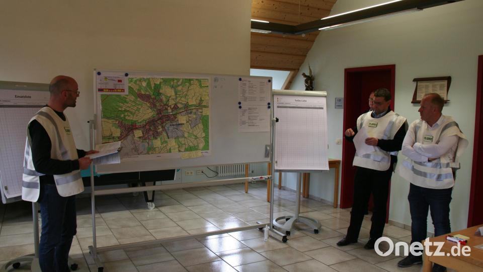Sascha Fritzsche (links) von der Stadt Schnaittenbach erläutert dem Krisenstab im Rahmen einer Lagebesprechung die aktuelle Lagekarte, v. r. Bürgermeister Marcus Eichenmüller und Kommandant Michael Werner. Bild: wfw