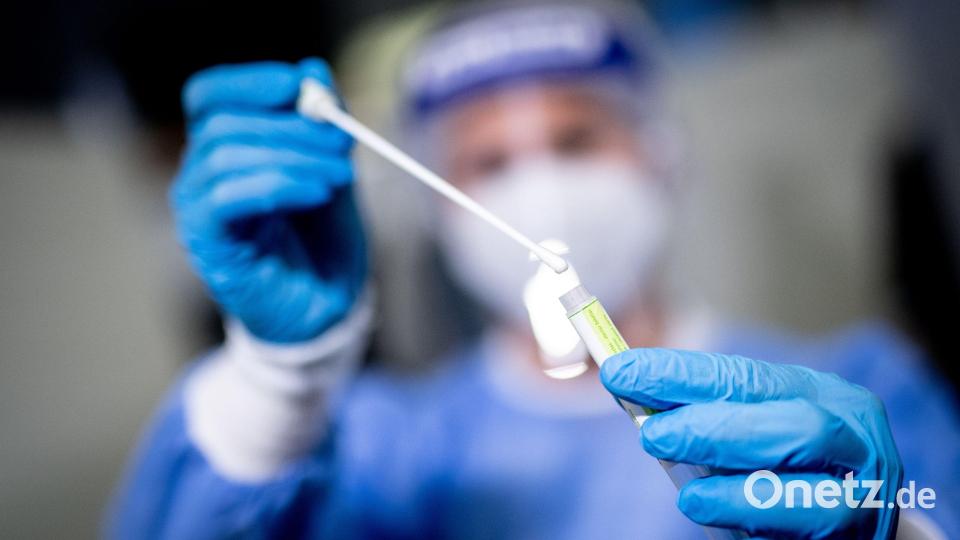 Eine Mitarbeiterin hält in einem Covid-19-Testcenter die Probe von einem Rachenabstrich in den Händen. Im Landkreis Tirschenreuth gab es innerhalb einer Woche 261 neue Coronafälle. Symbolbild: Matthias Balk/dpa