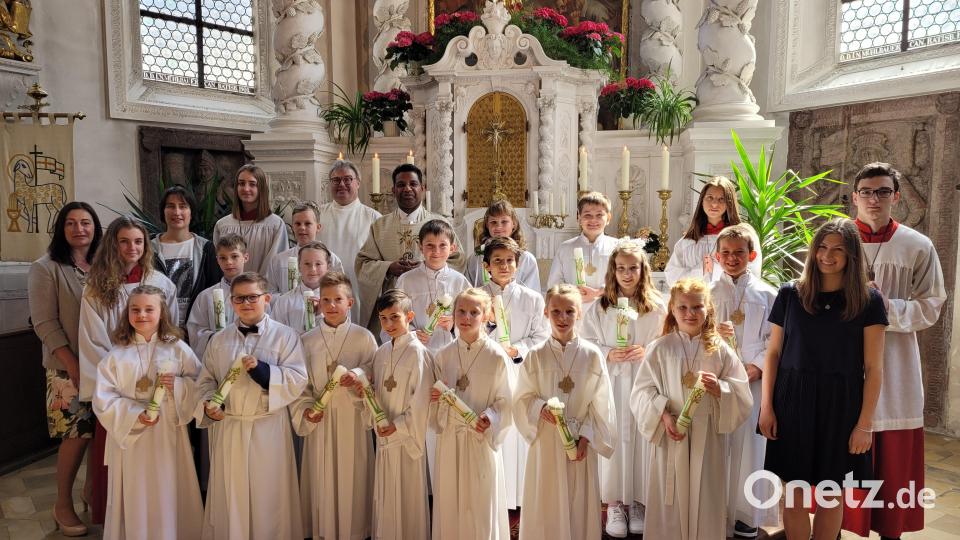 Mit den 16 Kindern der ersten Gruppe freuen sich Pfarrer Georg Parampilthadathil (hinten, Fünfter von links), Pastroalreferent Andreas Hartung (hinten, Vierter von links), Religionslehrerin Reinhilde Bodensteiner (Dritte von links), Schulleiterin Silke Schmid (links) und Klassenleiterin Julia Konrad (Zweite von rechts) über die erste Heilige Kommunion Bild: hir