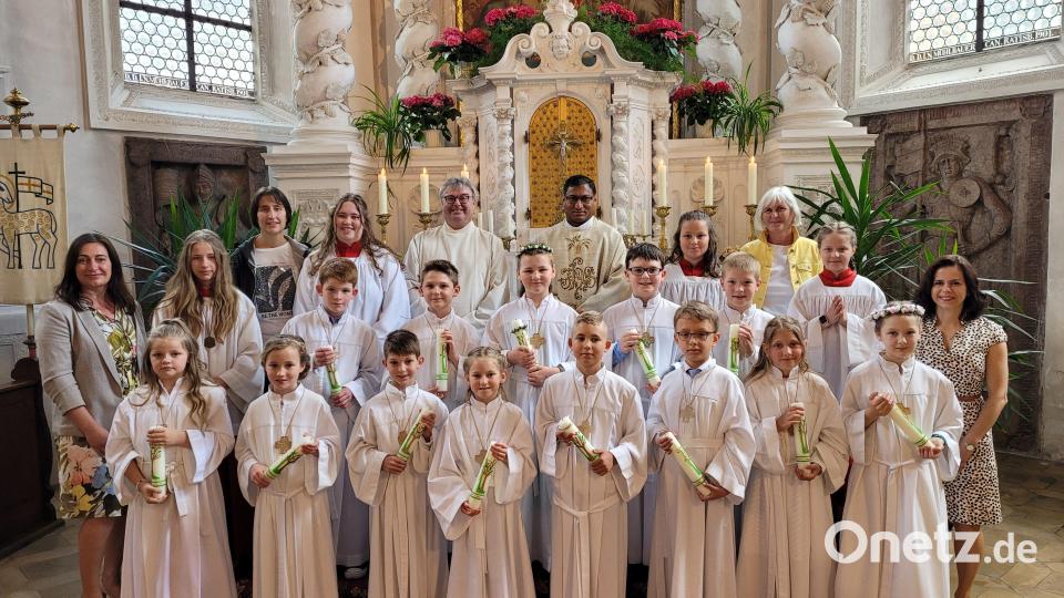 Mit den 13 Kindern der zweiten Gruppe freuen sich Pfarrvikar Robin Kuzhivelil (hinten, Dritter von rechts), Pastroalreferent Andreas Hartung (hinten, Vierter von rechts), die Religionslehrerinnen Reinhilde Bodensteiner (Dritte von links) und Veronika Strahberger (Vierte von rechts), Schulleiterin Silke Schmid (links) und Klassenleiterin Carolin Folsom (rechts) über die erste Heilige Kommunion Bild: hir