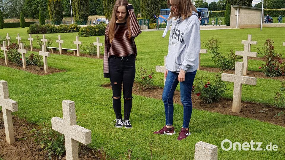 Zwei polnische Mädchen haben auf dem Soldatenfriedhof in Urville das Grab eines Gefallenen gefunden, der den gleichen Nachnamen wie eine der beiden hat. Der Krieg mag für sie weit in der Vergangenheit liegen, doch schon fr ihre Großeltern war er möglicherweise lebensverändernd. Bild: Judith Lehner