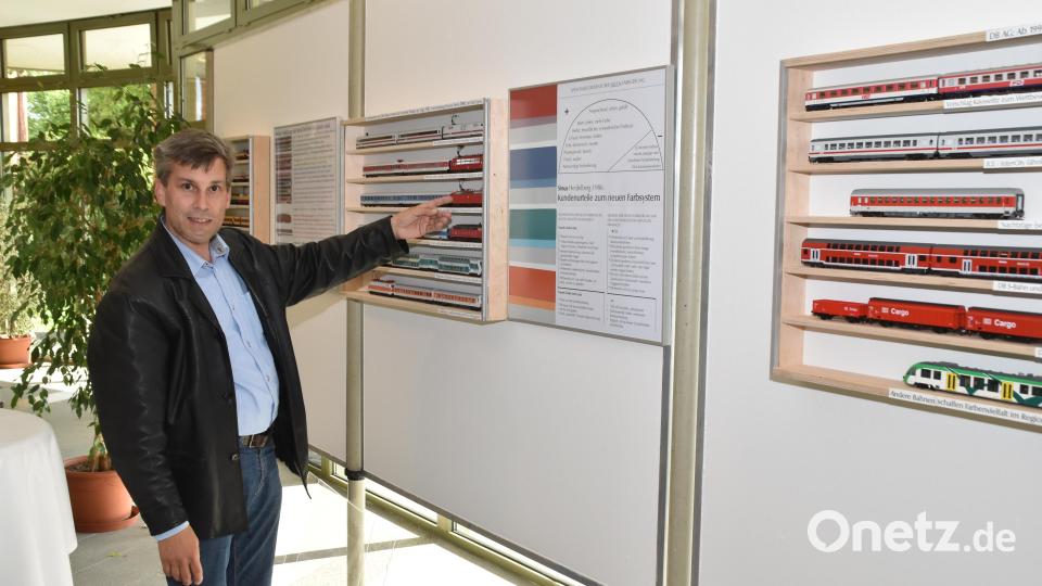 Derk Bodack, der Sohn des Kurators der Ausstellung, zeigt Beispiele der Farbgebung der 90er-Jahre. Bild: hcz