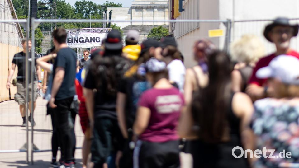 Besucher warten, dass die Absperrung zur Hauptbühne geöffnet wird. Bild: Daniel Karmann/dpa