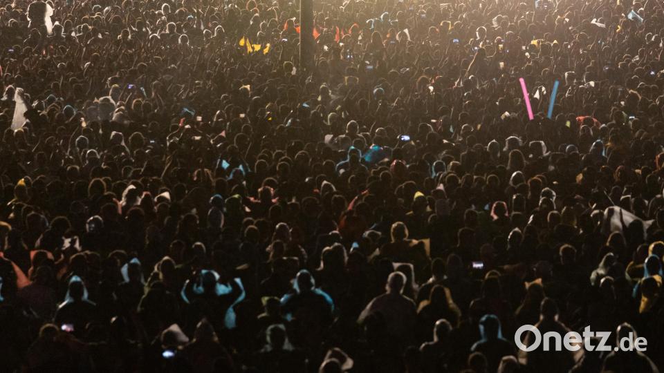Besucher verfolgen ein Konzert. Bild: Daniel Karmann/dpa
