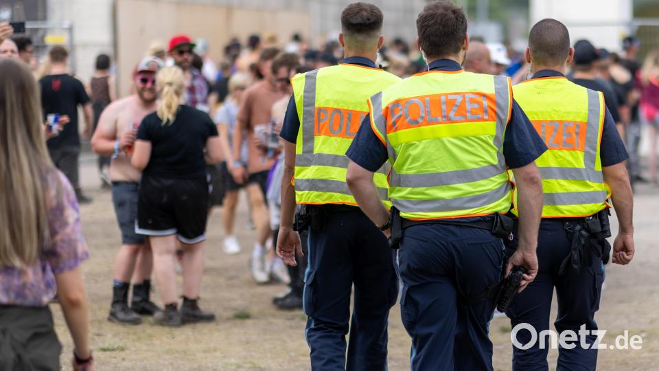 Polizisten gehen über das Gelände. Bild: Daniel Karmann/dpa