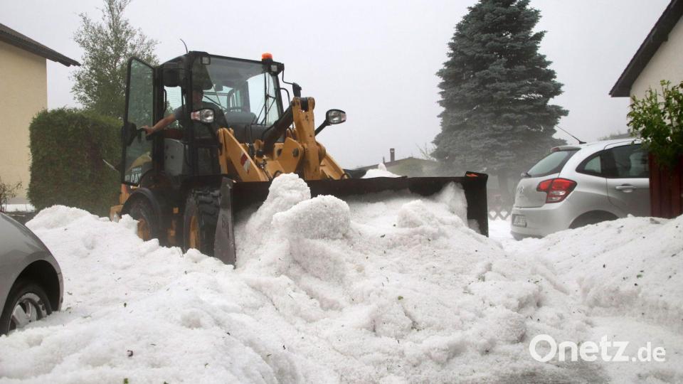 Kein Schnee, sondern Hagel: Ein Radlader im Einsatz in Weiler im Allgäu. Bild: Davor Knappmeyer/dpa