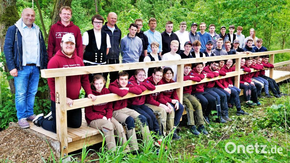 Viele Hände machen der Arbeit bald ein Ende, heißt es. Und wenn 38 kräftige Schüler der Schreiner- und Zimmererklassen anpacken, geht was vorwärts. Den Belastungstest zum Schluss hat der Bohlensteg problemlos bestanden. Bürgermeister Gerhard List und Fachoberlehrer Manfred Häring (hinten, von links) freuen sich darüber. Bild: jml