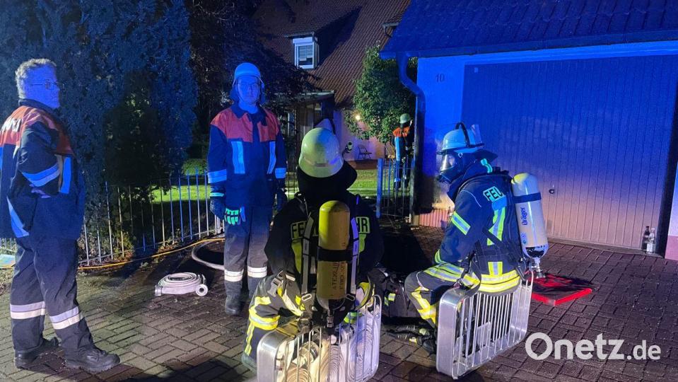 Feuerwehrleute mit schwerem Atemschutz bereiten sich auf den Einsatz im verrauchten Keller vor. Bild: lei
