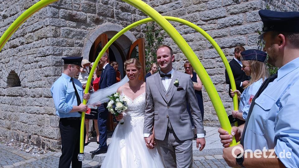 Die frisch verheirateten Stephanie und Martin Kastner zogen aus der Peterskriche aus und die Feuerwehr Erbendorf stand Spalier, ganz traditionell mit einem Feuerwehrschlauchtunnel. Bild: fks
