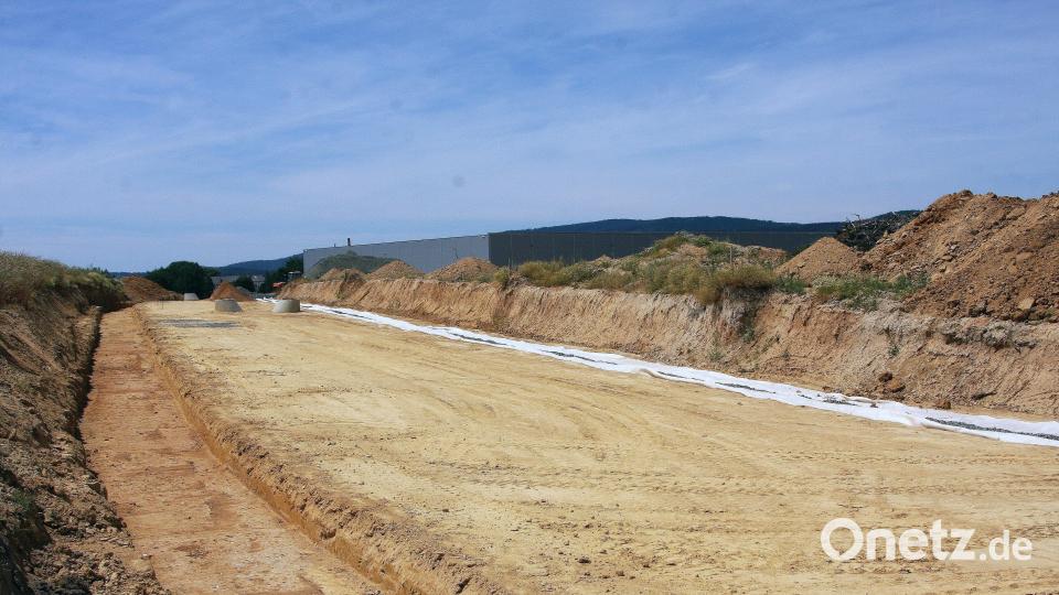 Derzeit laufen die Straßenneubauarbeiten im interkommunalen Industrie- und Gewerbegebiet bei Wiesau. Im Hintergrund die bereits bestehende Logistikhalle der Firma Ziegler. Bild: wro