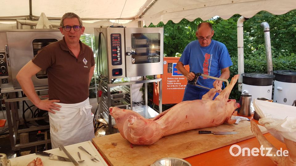 Im Küchenzelt ging es zu wie in der Metzgerei: Peter Zimmermann (rechts) bereitet das Schwein professionell mit einer Knochensäge für den Grill vor. Bild: Tobias Gräf