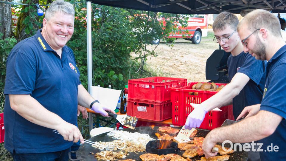 Kommandant Bernhard Schmidt (links) stand höchstpersönlich am Grill, um die Zwiebeln für den Renner des Abends, eine Steaksemmel mit Zwiebel und Käse, zuzubereiten. Bild: JOCHEN NEUMANN 
ERBENDORF