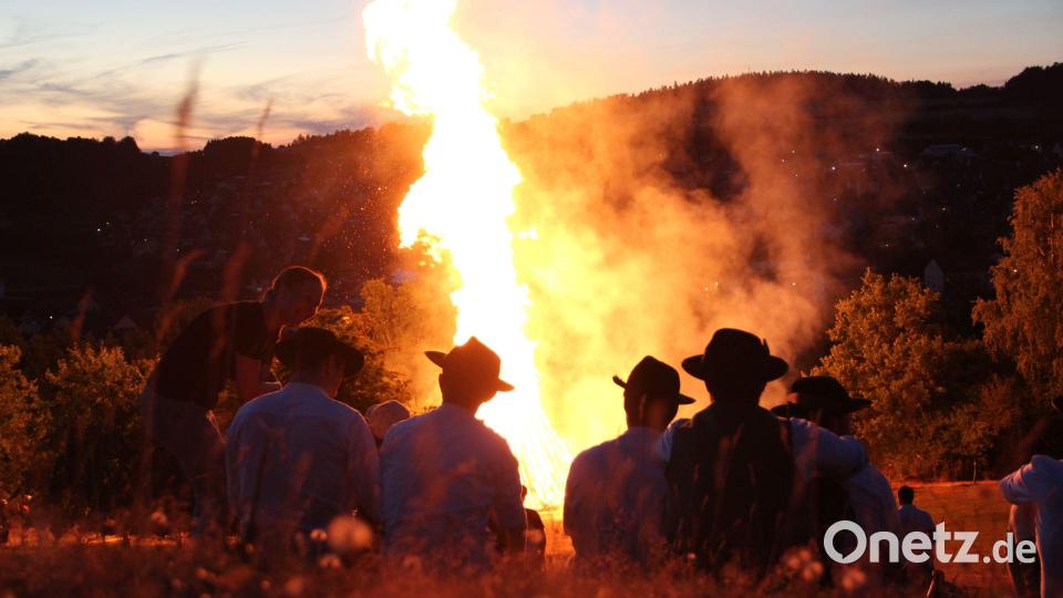 An den Hüten sind sie zu erkennen: Die Johannisbergschützen im Feuerschein. Bild: gri