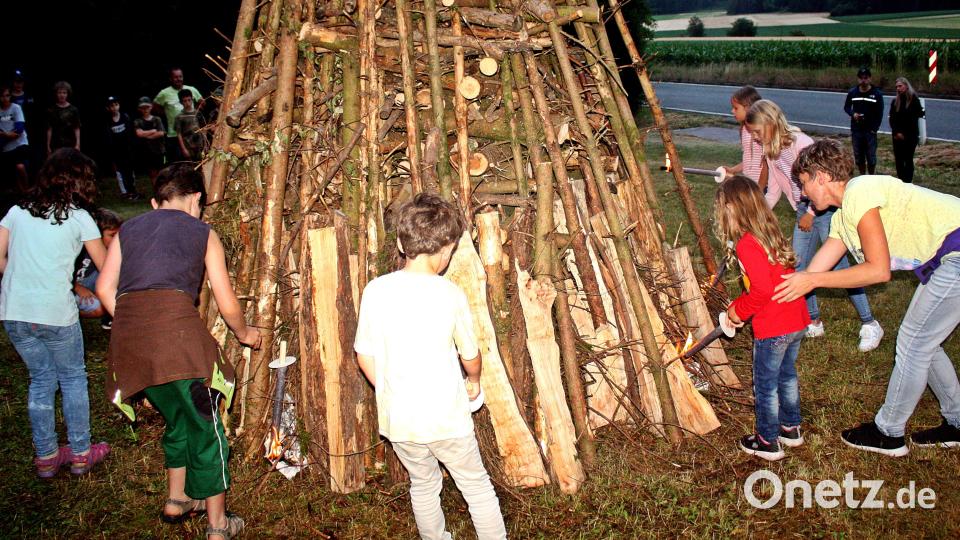 Die Kolpingjugend zieht mit Fackeln zum Holzstoß. Die Kinder lassen dann unter Aufsicht den Funken überspringen. Bild: R. Kreuzer