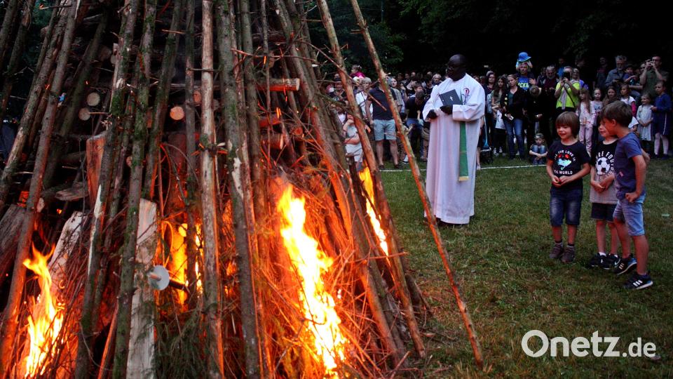 Die Kolpingjugend zog mit Fackeln zum Feuer. Pfarrvikar Robert Amandu segnete das Feuer. Die Gäste und Besucher trafen sich dann an den aufgestellten Bänken und Tischen, nachdem das Feuer abgebrannt war. Bild: R. Kreuzer