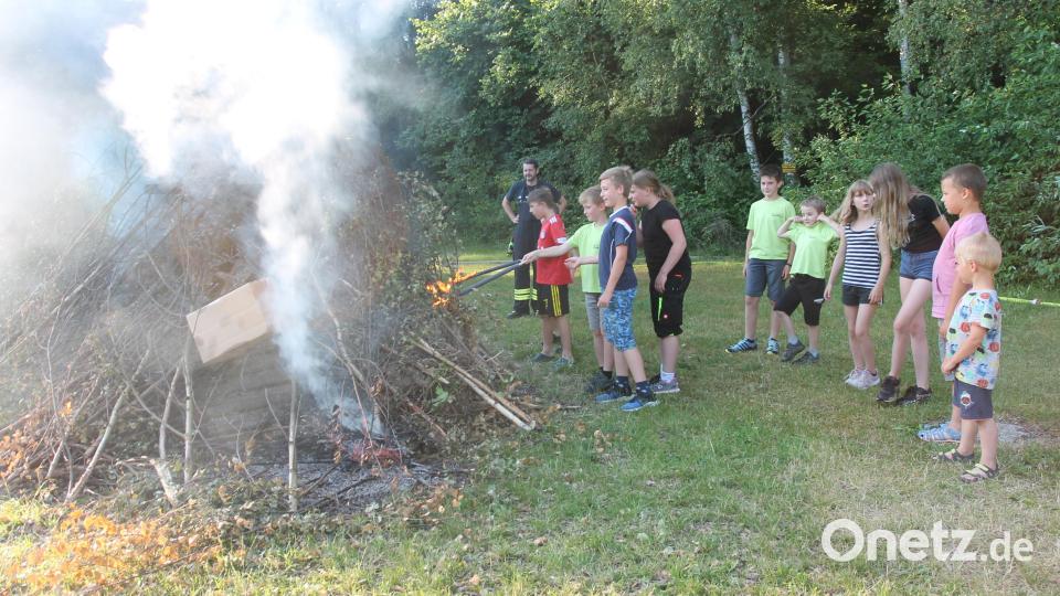 Die Mädchen und Jungen entzünden am Feuer ihre Fackeln. Bild: pi