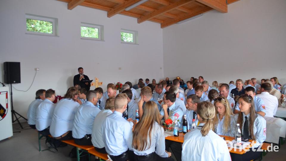 Pfarrer Günter Daum (stehend) zelebrierte in der Fahrzeughalle einen ökumenischen Gottesdienst. Bild: ak