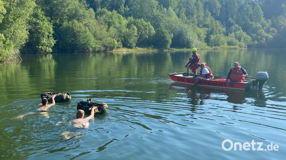 Zum Ende der Durchschlageübung mussten die Bundeswehrsoldaten mit ihrem Sturmgepäck schwimmend den Neusorger Steinbruch durchqueren. Kräfte der Wasserwacht aus Kemnath und Waldsassen sicherten sie mit ihrem Boot dabei ab. Bild: öt
