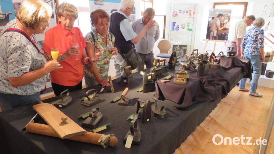 Die Besucher der Vernissage werfen die ersten Blicke auf die Bügeleisen. Bild: adj