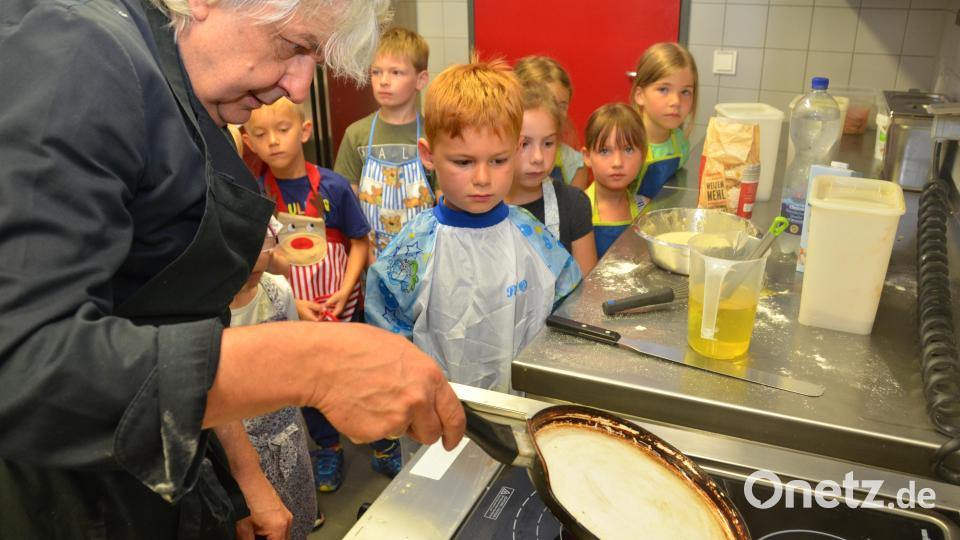 Die Pfanne muss richtig heiß sein, erklärt Küchenchef Gerd Reinhardt in der Küche der Mensa der Pfalzgraf-Friedrich-Mittelschule den Vorschulkindern aus dem Kindergarten Don Bosco. Bild: dob