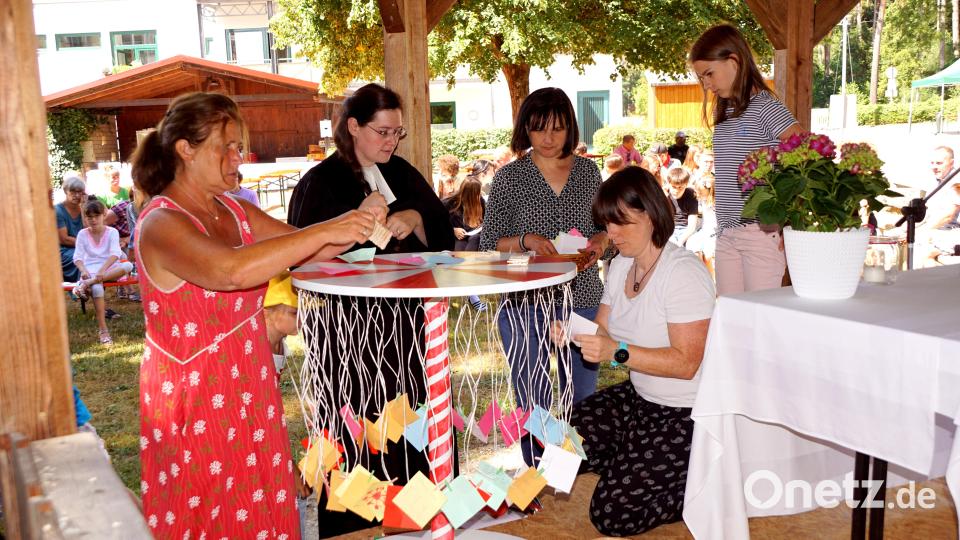 Andrea Rahn, Pfarrerin Kathrin Spies, Susanne Hassel und Steffi Danzer befestigen die Zettel mit den vermerkten Mittelpunkten am Karussell, um es dann, als Symbol des Lebens, zum Drehen zu bringen. Bild: bkr