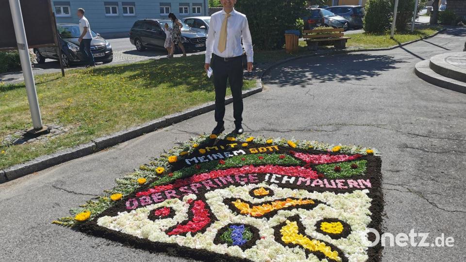Pfarrer Martin Rupprecht bewundert den beeindruckenden Blumenteppich vom Frauenbund. Bild: gz