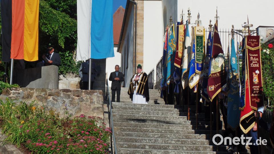 Eingebunden in dem Kirchenzug zur Pfarrkirche „Sankt Michael“ war auch ein Totengedenken am Ehrenmal, mit der Verlesung der Namen von Gefallenen, Vermissten und Verstorbenen der beiden Weltkriege. Pfarrer Sven Grillmeier (Bildmitte rechts) sprach Worte des Gedenkens, (links daneben) Pater James. Bild: br