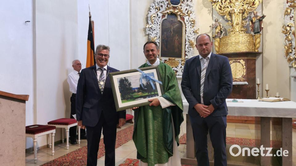 Bürgermeister Reiner Gäbl und Stellvertreter Thomas Kleber überreichen Pfarrer Martin Rupprecht ein Bild von Eslarn. Bild: gz