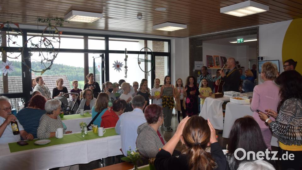 Die Besucher bei Kaffee und Kuchen vom Elternbeirat, werden von den Kindern mit Rektor Herbert Kraus (Gitarre) unterhalten. Bild: fz