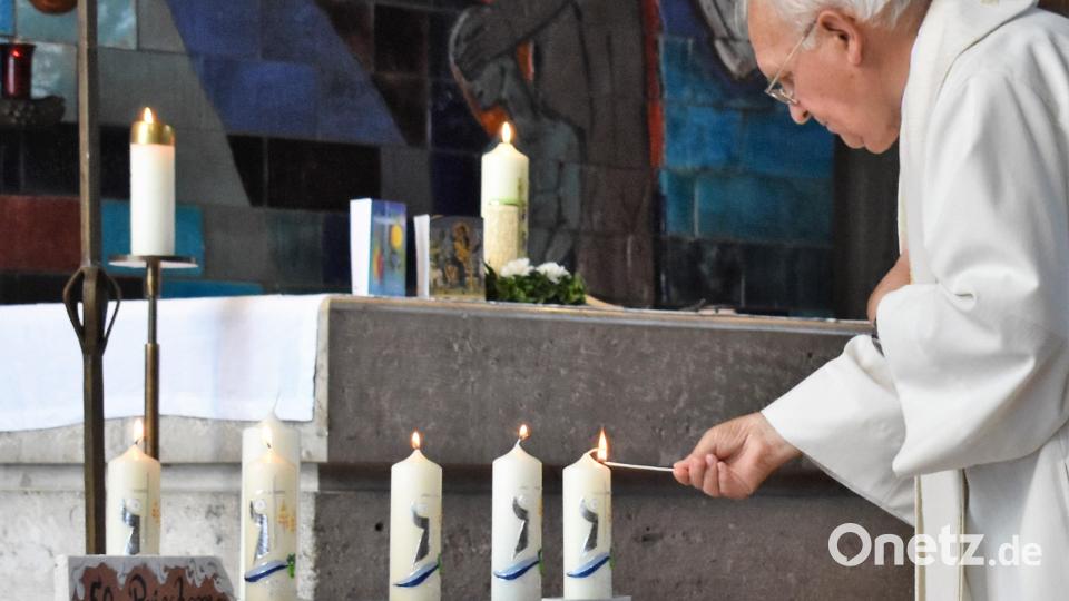Pfarrer Gerhard Schmidt zündet Kerzen für die verstorbenen Pfarrer an. Bild: rgr