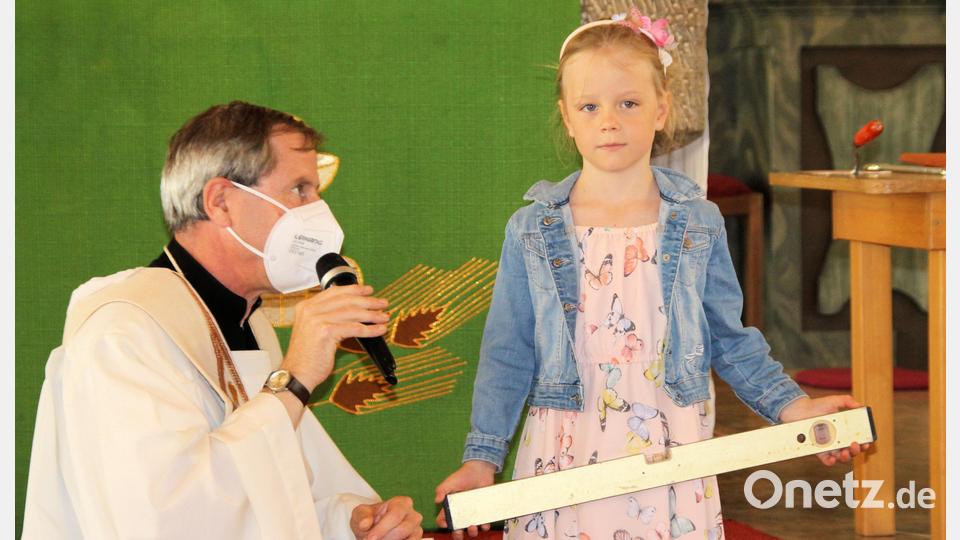 Die Kinder bringen für jede am Bau beteiligte Familie ein Symbol zum Altar. Bild: bjo