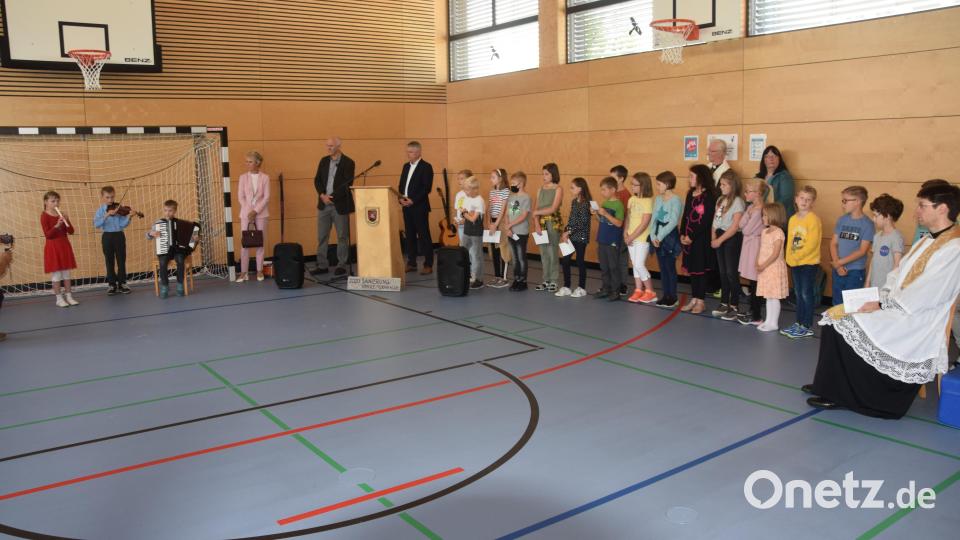 Kinder musizieren, tragen Gedichte vor und singen bei der Einweihung ihrer &quot;neuen Schule&quot;. Schulamtsdirektorin Christine Söllner (stehend links) spricht von einer &quot;schulischen Brücke in die Zukunft&quot;. Bild: fz