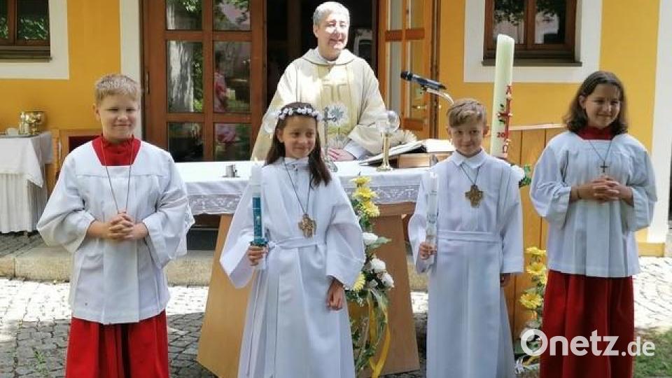 Die Kommunionkinder Lena Neumann und Lukas Gleißner zusammen mit H.H. Pfarrer Adam Nieciecki und den Ministranten Luisa und Lukas Pressl. Bild: exb/Talina Winter