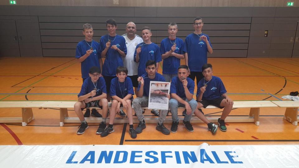 Stolz präsentieren die Schüler der Dreifaltigkeits-Mittelschule ihre Bronzemedaille (stehend von links): David Schmeller (6b), Lenny Kulke (7a), betreuender Lehrer Thomas Gebele, Ibo Issa (6a), Andre Krause (7b), Tim Oberndorfer (8c), (sitzend von links) Dominik Koller (7b), Leo Cario (6a), Rus Juqi (7a), Nourallah Alshaas (6a) und Luai Khalaf (6b). Bild: Thomas Gebele