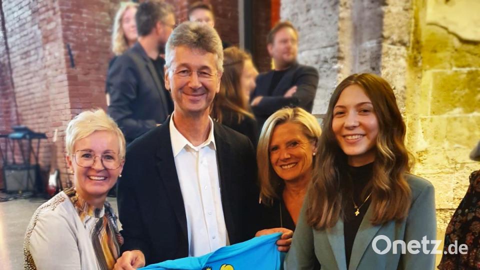 Bei der Ehrung in München hielt Kultusminister Piazolo sogar das Schul-T-Shirt der ausgezeichneten Schule Schnaittenbach in den Händen. Die Schulleiterin Michaela Bergmann (links), Konrektorin Sabine Spindler (Zweite von rechts) und Schulsprecherin Anna Bierler (rechts) waren darüber mehr als erfreut. Bild: Kultusministerium Bayern/exb