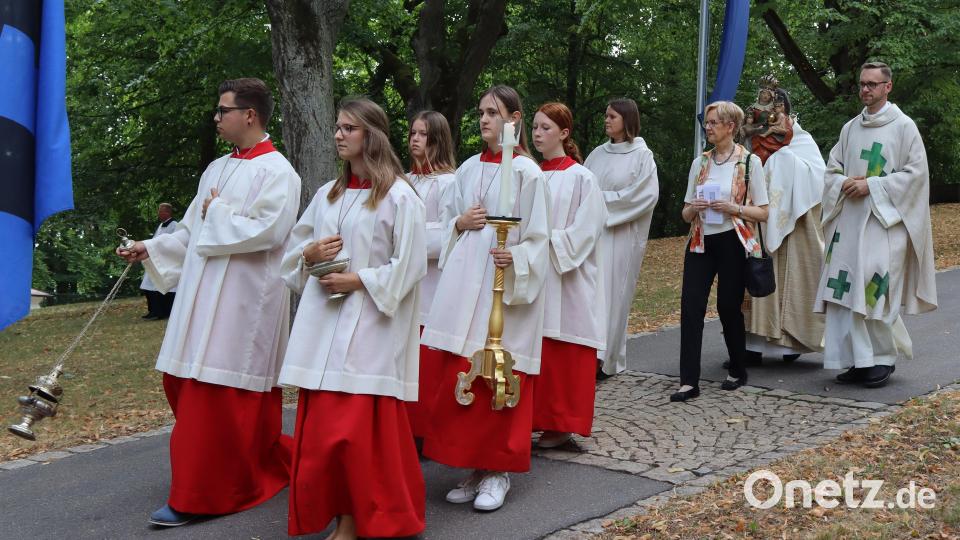 Pfarrer Herbert Mader (hinten) trägt das Gnadenbild St. Anna-Selbdritt zum Freialtar. Bild: mfh