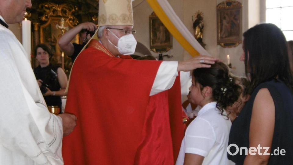 Die segnende Handauflegung des Bischofs und die Rückenstärkung der Patin soll im Leben tragen. Bild: mma