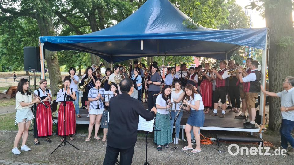 Die Stadtkapelle Kemnath teilt sich für einen spontanen gemeinsamen Auftritt die Bühne mit dem &quot;Korean Wind Orchestra&quot;. Bild: sne