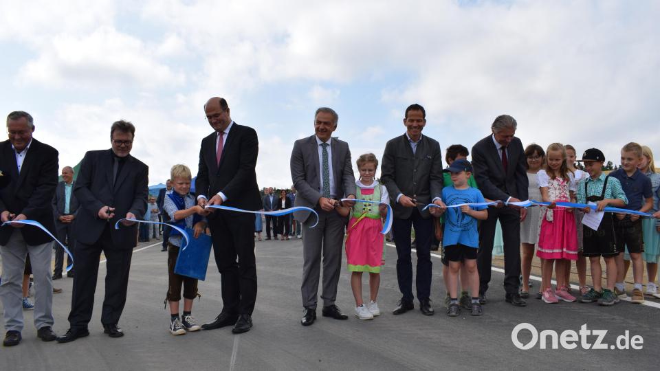 Die Kinder der Klasse 3a der Grundschule Plößberg durften gemeinsam mit den Ehrengästen das Band zur Verkehrsfreigabe der Trasse durchschneiden. Im Bild: Bürgermeister Lothar Müller, MdB Albert Rupprecht, Landrat Roland Grillmeier, Finanzminister Albert Füracker und Roman Beer, Leiter des Staatlichen Bauamts Amberg-Sulzbach (von rechts). Bild: szl
