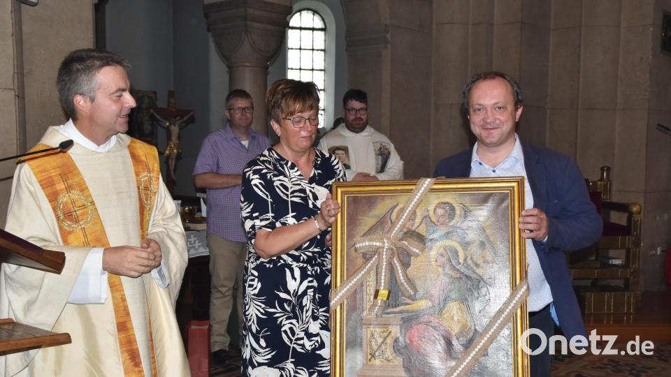 Stadtpfarrer Markus Schmid und Pfarrsekretärin Anna Schwägerl beschenken Piotr Pajak anlässlich seiner Ernennung zum "Leuchtturmmusiker" mit einem Bild des heiligen Laurentius. Bild: hcz