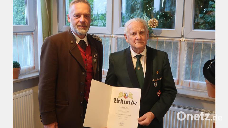 Bezirksschützenmeister Harald Frischholz verleiht Günter Plügge die Große Ehrennadel in Silber des Schützenbezirks Oberpfalz. Bild: Kunz