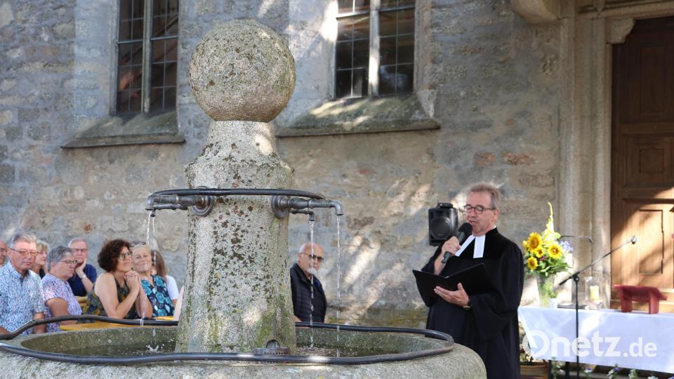 Pfarrer Klaus Weber predigte vor dem Brunnen im Kirchhof, der im Mittelpunkt des familienfreundlichen Gottesdienstes stand. Bild: flt
