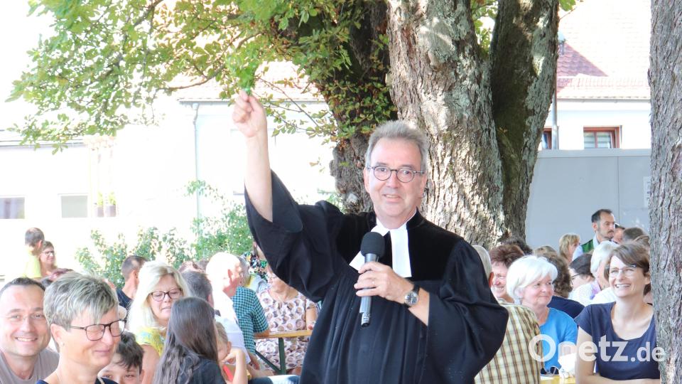 Pfarrer Weber besprengte die Gottesdienstbesucher mit dem Wasser aus dem Brunnen. Bild: flt