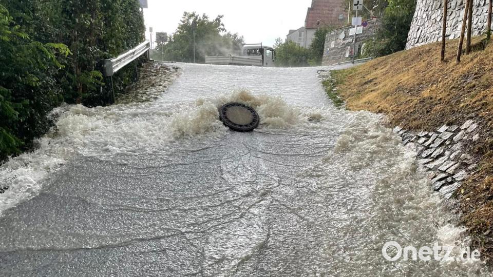 Das Wasser reißt einen Gullideckel aus dem Boden. Bild: Feuerwehr Landkreis Cham/Kreisbrandinspektion Cham