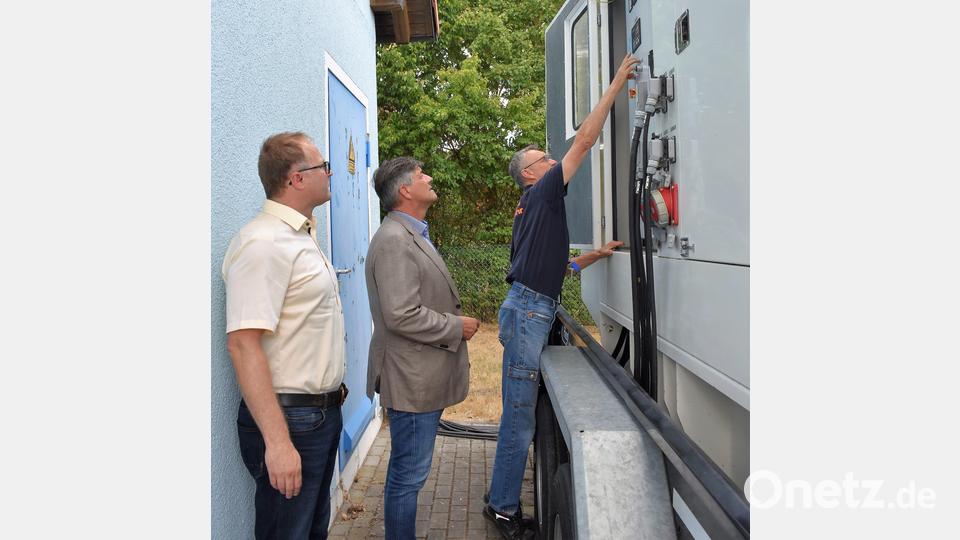 Wassermeister Günter Rauh (rechts) und der Vorstand der Stadtwerke Frank Neubauer stellen Bürgermeister Edgar Knobloch (Mitte) das mobile Notstromaggregat vor. Bild: rgr