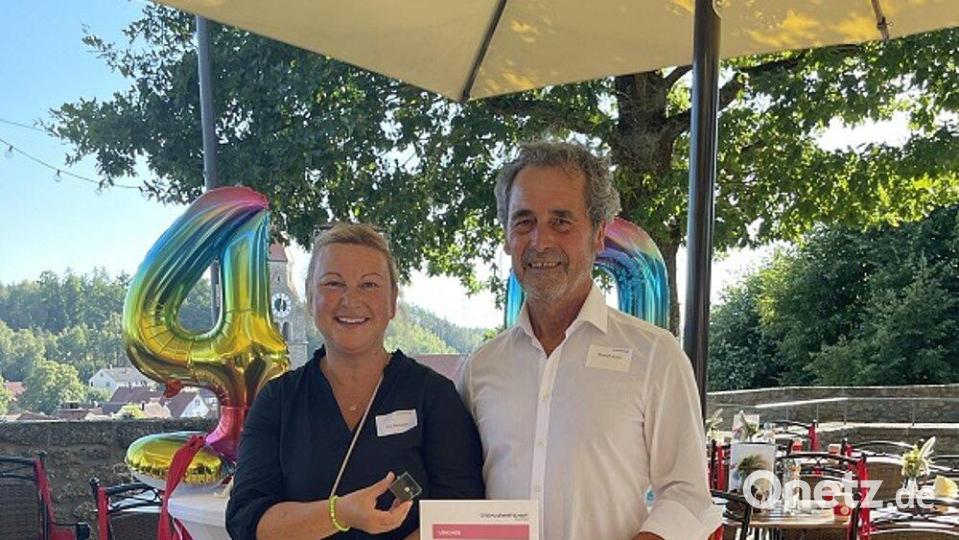 Pia Schwarz, Geschäftsführerin von Schule-Wirtschaft Bayern, überreicht an Rudolf Kunz die Silberne Ehrennadel. Bild: Philipp Lippert/exb