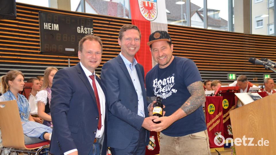 Einen Ein-Liter-Krug, gefüllt mit dem erstmals gebrauten Speichersdorfer Bürgerfestbier, überreichten Bürgermeister Christian Porsch (links) und Bierbrauer Steffen Waris (rechts) an Landrat Florian Wiedemann Bild: ak